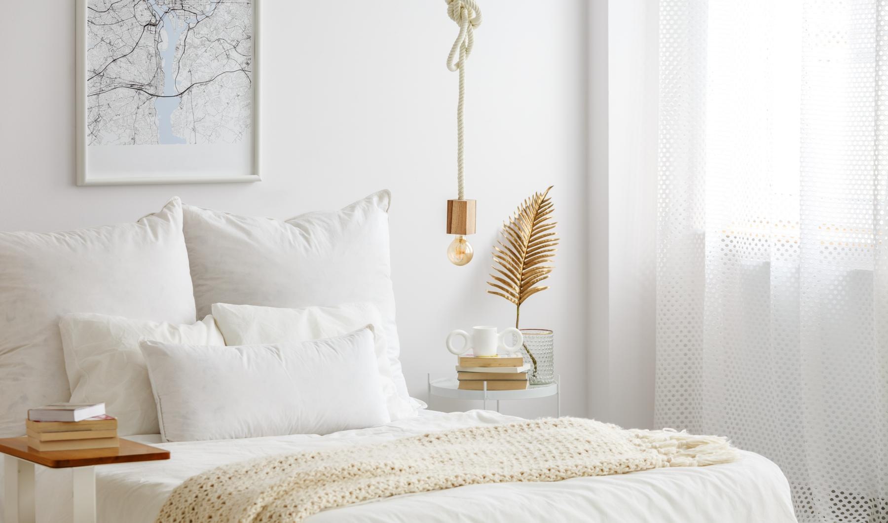 a bed with white sheets and a lamp on the side