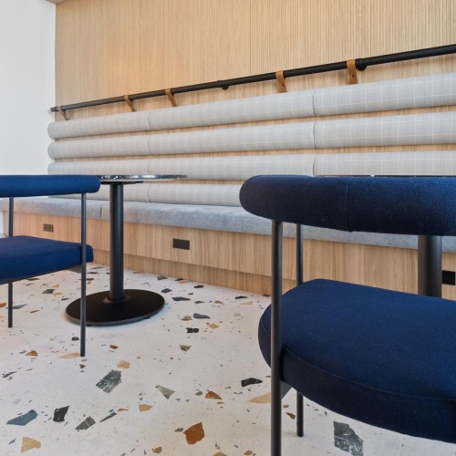 a group of blue chairs in a room with a wood wall